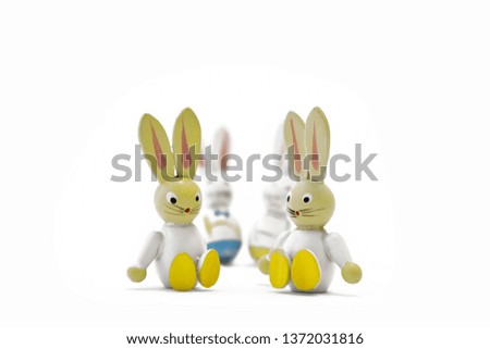 Two toy easter bunnies sitting side by side with their father and mother in the background. Happy family. Landscape format.