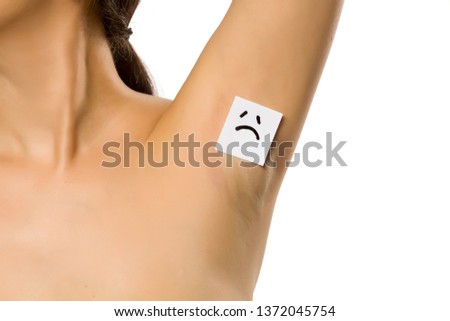 Woman shows her underarm with a sad face on her on white background