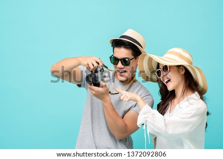 Happy young Asian tourist couple enjoying taking pictures on their vacation trip