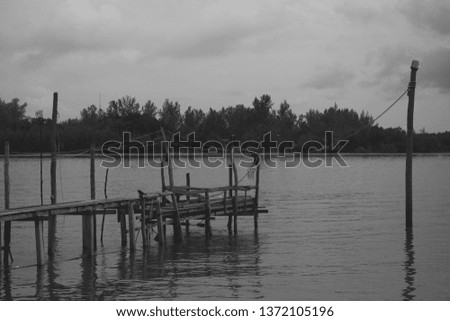The old wooden bridge extends into the water retro style
