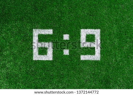 Football score 6:9.White numbers six and nine are drawn on the green grass,creative scoreboard