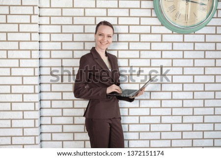 The female model uses a laptop in the office.