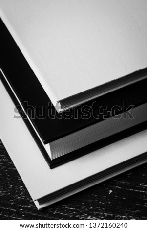Black and white books on a dark wooden table background.