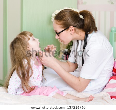 Pediatrician examining little girl's throat