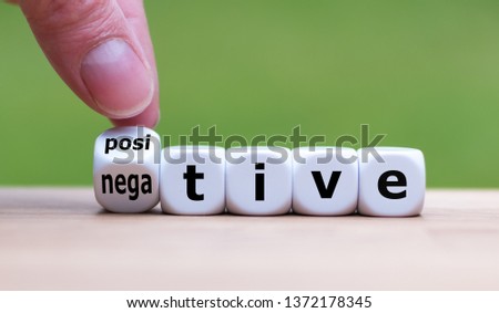 Hand turns a dice and changes the expression "negative" to "positive". Royalty-Free Stock Photo #1372178345