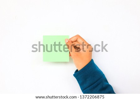 A hand holding green paper color with white background.