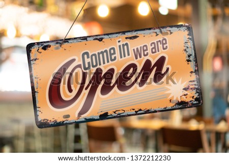 A business sign that says open’on cafe or restaurant hang on door at entrance. Vintage color tone style.