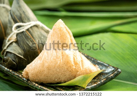 Zongzi - Close up, copy space, famous asian tasty food in dragon boat (duan wu) festival, steamed rice dumplings pyramidal shaped wrapped by bamboo leaves made by sticky rice raw ingredients