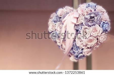 heart shape bouquet made of different flowers hanging on a wall