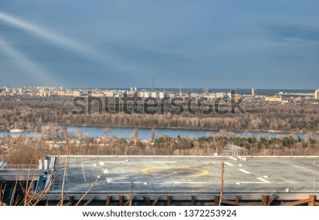 beautiful cityscape landscape with building in foreground with helicopter helipad on roof