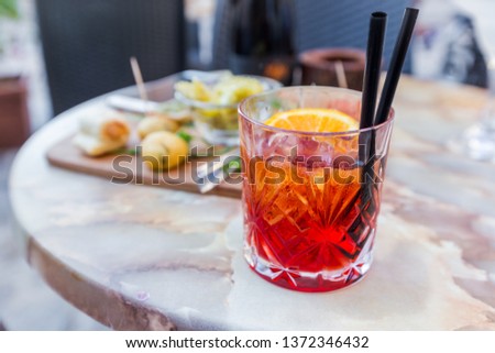 Mezcal Negroni cocktail Italian aperitivo on the table in the open area of restaurante