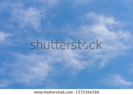 A blue sky with subtle dreamy white clouds.