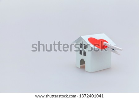 Simply minimal design with miniature white toy house and red heart isolated on white background. Mortgage property insurance dream home concept. Copy space