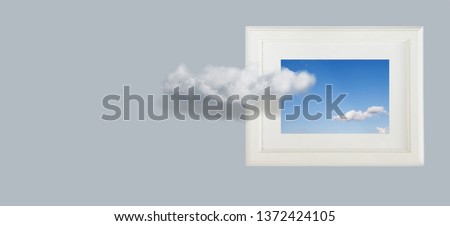 Conceptual image of sky clouds, photo frames on the wall.