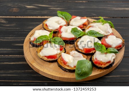 Mini eggplant pizza with mozzarella cheese, tomatoes and basil