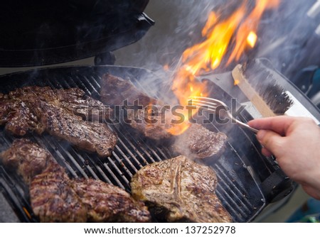 Flames grilling a steak on the BBQ