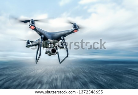 Dark drone in flight over the city. Royalty-Free Stock Photo #1372546655