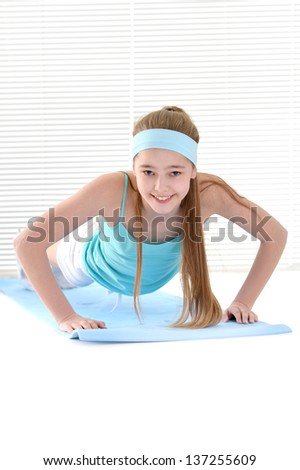 A nice young girl engaged in gymnastics in the gym