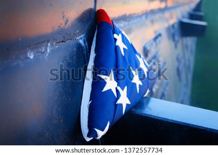 American flag on the background of grass and slab of the dead. Concept for Memorial Day and other holidays of the United States of America