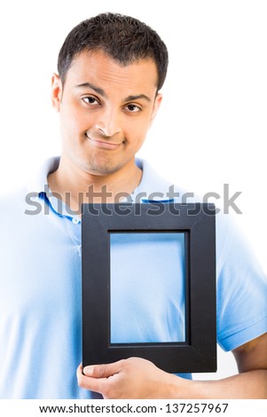 A young man holding a black frame in front of his heart