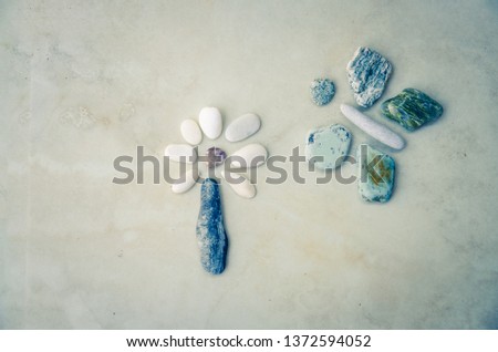 creative art image of flowers and butterfly made from colorful pebbles