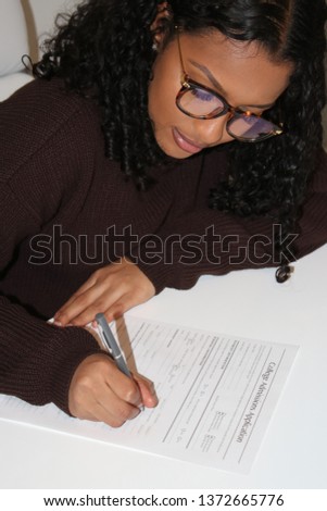Student submitting her application for college admission. Royalty-Free Stock Photo #1372665776