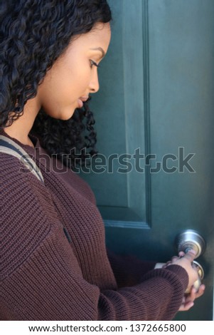 College student with backpack turning key to dormitory door. Royalty-Free Stock Photo #1372665800