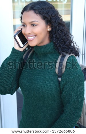 College student on her way to school carrying a back pack while talking on cell phone. Royalty-Free Stock Photo #1372665806