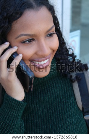  College student on her way to school carrying a back pack while talking on cell phone. Royalty-Free Stock Photo #1372665818
