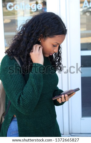  College student on her way to school carrying a back pack while talking on cell phone. Royalty-Free Stock Photo #1372665827