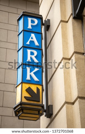 "Park" sign pointing to the entrance to an underground parking garage, at a shopping mall