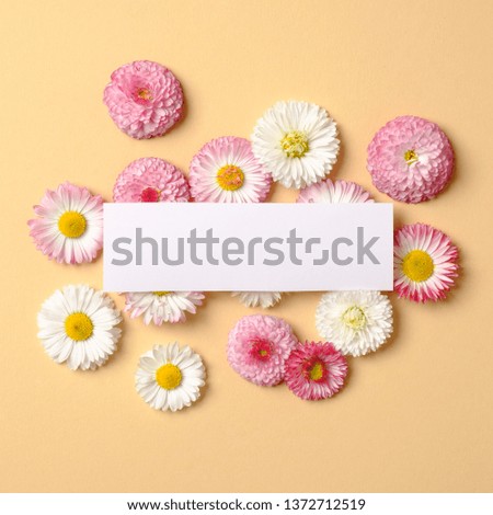Spring holiday concept. Creative layout made of blank empty card with spring flowers on pastel yellow background. Flat lay composition. Top view, overhead.
