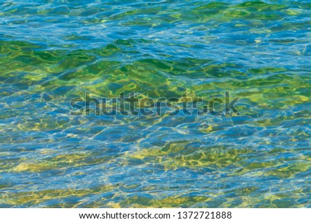 Sea water with waves and reflection in different light. Texture background for design.