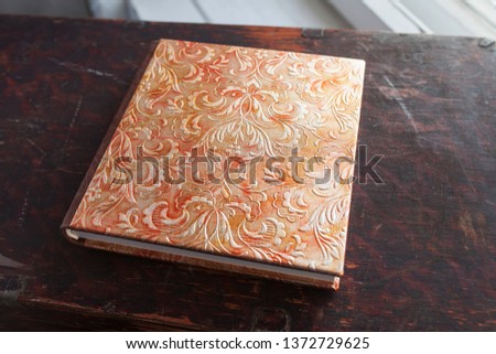 Photobook with a cover of genuine leather. Beautiful cover with gold stamping on dark brown background of old wood