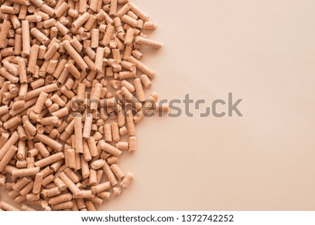 Wooden pellets background, pattern. Close up natural wood pellet. Ecological heating, renewable energy Biofuels. Top view ecological fuel for solid fuel boilers on light background with place for text