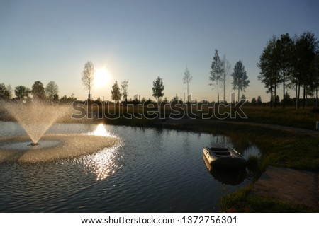 Lake fountain boat forest. Natural composition The photo