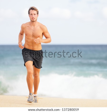 Running man jogging on beach. Male runner training outside working out. Fit young male sport fitness model exercising in full body in summer. Handsome strong caucasian man in his twenties.