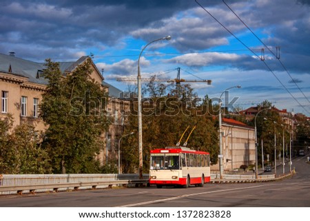 An old white-red trolleybus on the background of the building rises on the bridge. Vilnius, Lithuania. Royalty-Free Stock Photo #1372823828
