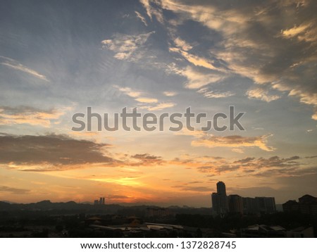 Beautiful golden sunrise views. There is a cloud group of blue and calm clouds. foreground silhouette.