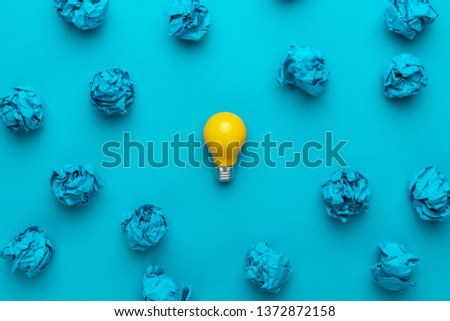 new idea concept with crumpled office paper and light bulb. top view of great business idea concept over blue background. creative solution during brainstorming session concept Royalty-Free Stock Photo #1372872158