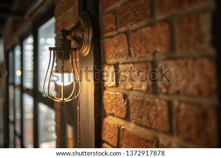 Antique electronic lamp, red wall lamp, high wall lamp, soft light.Red brick wall.Open chain, turn off the lights.hanging at the red brick wall in the building,Wall light brown brick,soft focus. Royalty-Free Stock Photo #1372917878