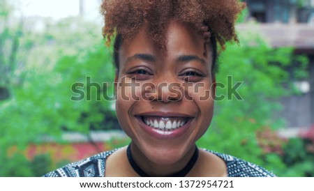 Close up of young African woman looking at camera smile at Chengdu street. delight happy black young woman smile at Asian china urban city  