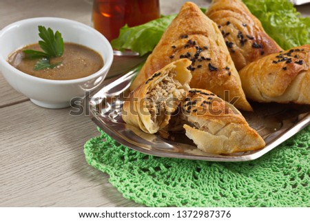 Plate with delicious  samsa with meat on gray background. Meat dish of the peoples of Central and Central Asia, dough, meat and onions, suitable for the Nauryz or Navruz holidays,