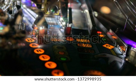 Pinball machine in a dark room Royalty-Free Stock Photo #1372998935