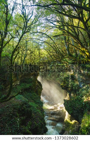 The sun's rays over the river. Large rocks and boulders along the river. Okatse Canyon. Rest in Georgia. Nature in the Imereti region.