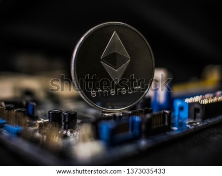 Coin ethereum on the background of a microcircuit. Crypto currency etherium close-up. Mining. Crypto. Close up photo of silver ethereum coins on computer main board, concept of cryptocurrency mining