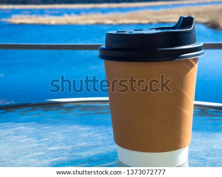 paper cup of coffee on natural morning background. Film effect.