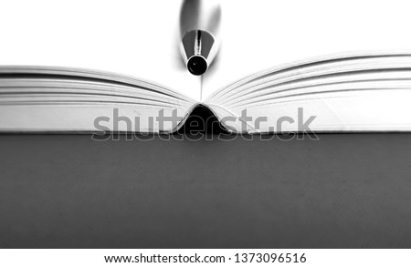 Black and white shot of a pen in a notebook, on dark background with copy space . Concept of being a writer or blogger. Royalty-Free Stock Photo #1373096516