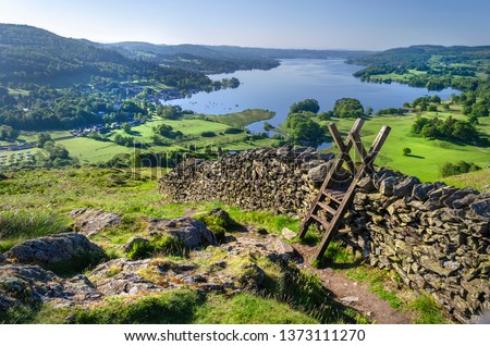 A morning shot of Lake Windermere showing the stone walling and the stile providing passage over the wall. 
 Royalty-Free Stock Photo #1373111270
