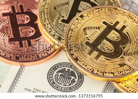golden bitcoin coin and us dollars